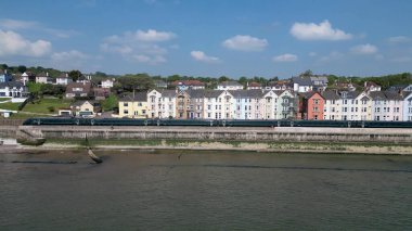 Dawlish, Güney Devon, İngiltere: Viktorya dönemi teras evlerinin önünden geçen şehirlerarası bir trenin geniş bir görüntüsü. Ana hat Penzance, Cornwall 'a hizmet veriyor. Güney Devon popüler bir İngiltere tatil beldesidir (Fotoğraf: 1 / 2).
