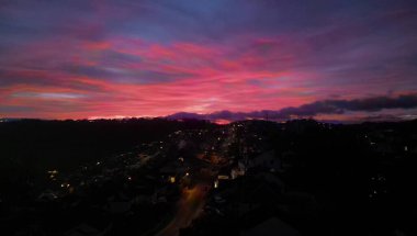 Paignton, Torbay, Güney Devon, İngiltere: DRONE VİEWS: Paignton banliyöleri üzerindeki ufuk çizgisini aydınlatan koyu kırmızı bir günbatımı. Paignton, İngiltere 'nin popüler bir tatil beldesi ve turistik merkezidir..
