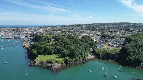 Brixham & Fishcombe Cove, Torbay, Güney Devon, İngiltere: Brixham limanında demirlemiş teknelerle Fishcombe Cove 'un yüksek açılı görüntüsü resmin solunda. Brixham, İngiltere 'nin popüler bir tatil beldesi ve su sporları meraklıları için bir mıknatıs..