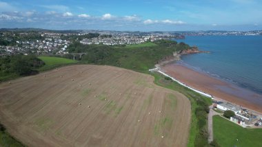 Broadbay, Torbay, Güney Devon, İngiltere: DRONE VİEWS: Broadbay 'e bakan saman balyaları ve Torbay denizi ile bir çiftlik alanı. Güney Devon hem popüler bir İngiltere tatil beldesi hem de büyük bir ekilebilir ve çiftlik hayvanları çiftliği bölgesidir..
