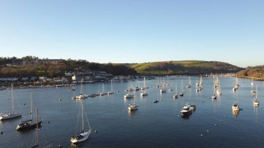 Dartmouth, River Dart, Güney Devon, İngiltere: DRONE ViEW: DRONE Dart Nehri 'ne demirlemiş tekne ve yatlar; Britanya Kraliyet Koleji nehrin sol kıyısında yer almaktadır. Dartmouth İngiltere 'nin popüler bir tatil beldesi ve denizciler arasında popüler..