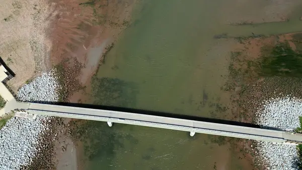 Budleigh Salterton, Doğu Devon, İngiltere: DRONE VİEW: River Otter 'ın ağzına yayılan yaya köprüsünün doğrudan yukarıdan görüntüsü. Halkımız, Dünya Mirası Sahili 'nin bir kısmını oluşturan kıyı patikasıyla kesişiyor..