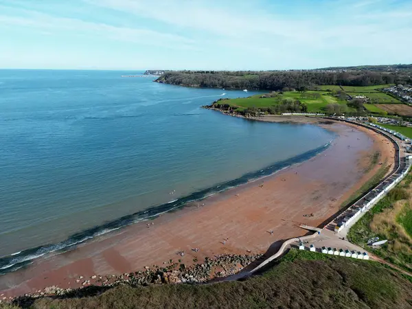 Broadbay, Torbay, Güney Devon, İngiltere: DRONE ViEW: Broadsand Beach ve beach barakaları; uzaktaki Berry Head ve Brixham limanı dış duvar. Torbay, ünlü ve güzel kıyı şeridi nedeniyle popüler bir İngiltere tatil beldesi..