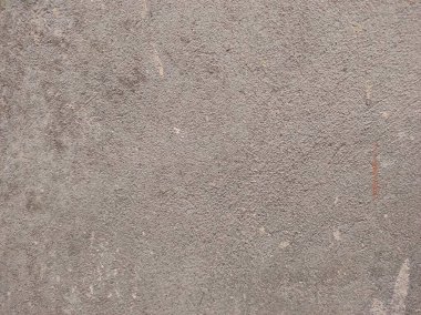 Soyut boya binanın duvarından soyuluyor. Yakın plan. Boya ve çatlaklarla kaplı kötü tamir edilmiş ön bina duvarı. Ortadaki boya parçası kayıp, kanatlı çatlak. Çizik ve çatlaklarla duvar dokusu. Kusursuz gri beton..