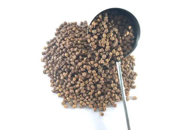 Beyaz arkaplanda kaşıkla kişniş otu yakın plan.