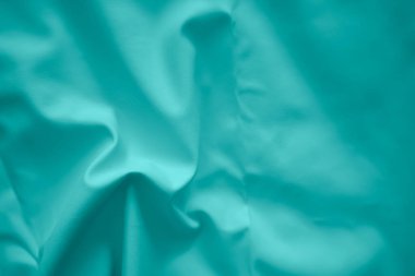 İpek, soyut desenli yeşil saten arkaplanda buruşmuştu. Soyut kumaş duvar kağıdı.