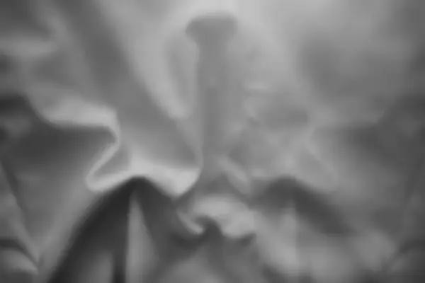 Açık gri ışık gölge efekti üzerine buruşmuş saten, soyut arkaplan dokusuna sahip. Soyut kumaş duvar kağıdı.