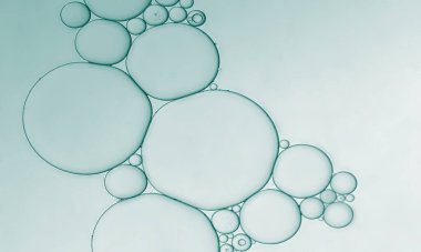 Oil serum bubbles pattern with pale blue green background. Art image.