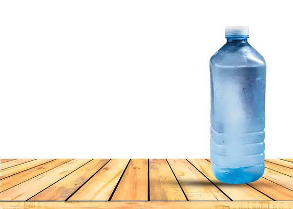 Masada beyaz arka planda izole edilmiş bir şişe soğuk su. Sağlıklı ve içki konsepti.