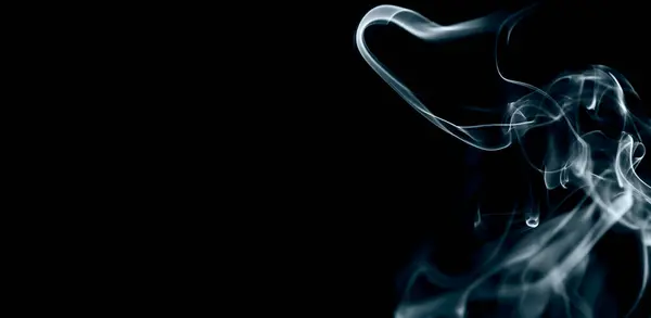 Mavi ışık efektiyle siyah arka planda izole edilmiş havada dönen soyut duman..