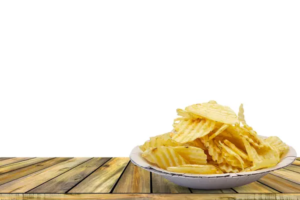 Patates cipsi kasede beyaz arka plandaki ahşap masada.