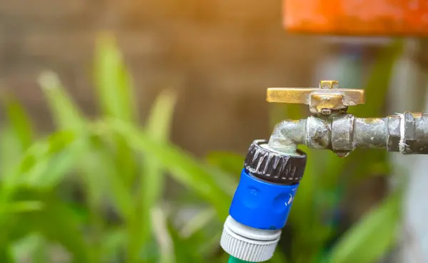 Su musluğu sızıntısı ve bulanık arka plan. Suyun korunumu kavramı kaydediliyor.