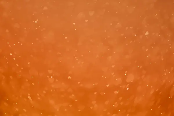 Kahverengi turuncu, bulanık bokeh simli. Sevgililer günü temalı kalp şekli, ışık parıltısı arkaplanı.