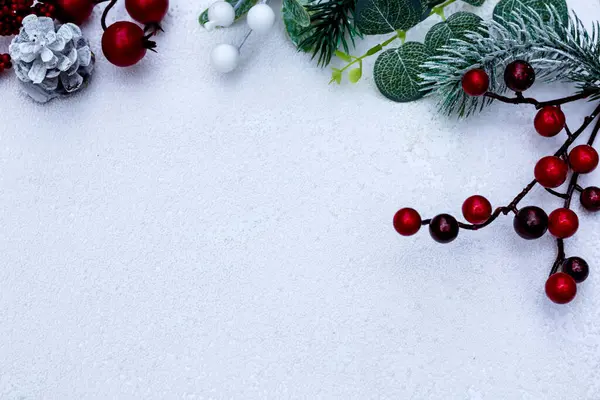 Yeni yıl süslemeleri ile kompozisyonun görüntüsü ve beyaz arkaplanda kırmızı çoban püskülü ve metin için kopya alanı.