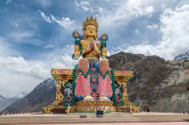 Maitreya Buddha heykeli Diskit Manastırı, Nubra Vadisi, Ladakh 'da Himalaya manzarasına bakıyor. Bu sembolik 32 metrelik heykel, kültürel, ruhani ve seyahat temalı görsel hikaye anlatımı için ideal şefkat ve barışı temsil ediyor..