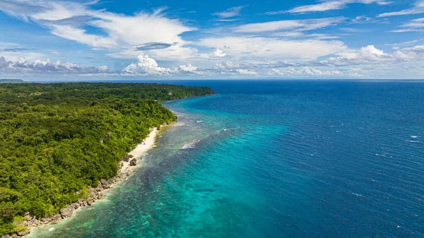 緑豊かな熱帯の島の美しい砂浜と海岸の小さな岩の形成 — ストック写真