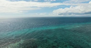 Mercan resifli deniz burnu, açık mavi gökyüzünün altında derin mavi deniz. Okyanus silueti. Siquijor, Filipinler.