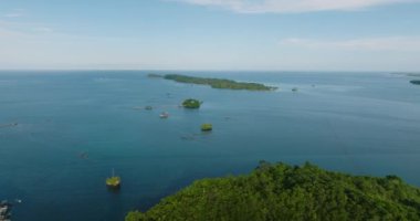 Mavi denizdeki küçük tropikal adanın balık çiftliği manzarası. Deniz Burnu. Mindanao, Filipinler.