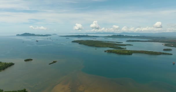 青い空と雲の下で熱帯の島とカルゴ船 — ストック動画