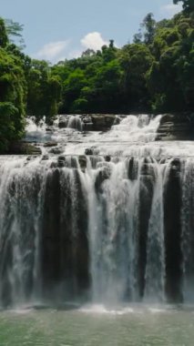 Ufacık bir şelale gibi güzel bir su perdesinin havadan manzarası. Mindanao, Filipinler. Dikey görünüm.