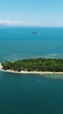 Adanın kumlu beyaz sahilinde teknelerle yapılan hava araştırması. Alingkakajaw Adası. Mavi denizdeki mercan kayalıkları. Mindanao, Filipinler. Dikey görünüm.