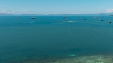 Hava Deniz Burnu: Mavi deniz ve bulutlu gökyüzü. Deniz yüzeyinde tekneler. Mindanao, Filipinler.