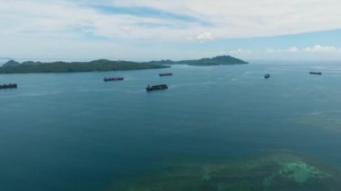Açık deniz suyundaki mercanlar. Tüccar ve kargo gemisiyle açık mavi deniz. Mindanao, Filipinler.
