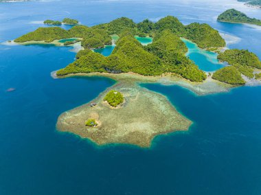 Göl kenarlı adaların tropikal manzarasının havadan görünüşü. Turkuaz su ve derin mavi deniz ufuk çizgisinin altında. Mindanao, Filipinler.