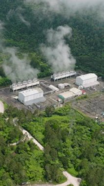 Kartallar yağmur ormanlarındaki jeotermal enerji santralini görüyor. Bir enerji santralinde yenilenebilir enerji üretimi. Mindanao, Filipinler. Dikey görünüm.