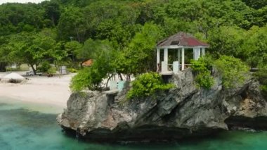 Salagdoong Sahili Resort 'un küçük adaya bakan deniz manzaralı insansız hava aracı görüntüsü. Siquijor, Filipinler.