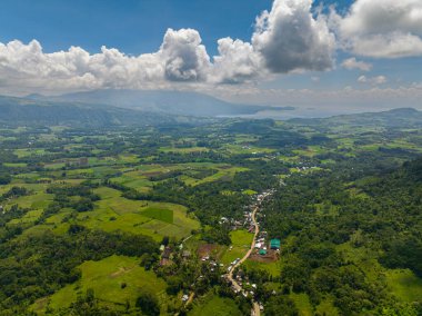 Dağ manzarası: yeşil ormanları olan dağlar ve tarım arazisi olan tarım çiftlikleri. Mindanao, Filipinler.