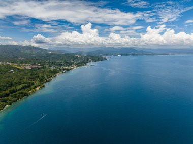 Tropik ada ve mavi deniz yüzeyi. Mavi gökyüzü ve bulutlar. Mindanao, Filipinler.