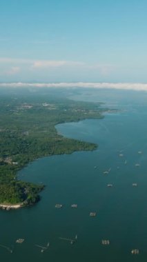 Ormanı ve derin mavi denizi olan tropik bir yer. Lanao del Norte. Mindanao, Filipinler. Dikey video.
