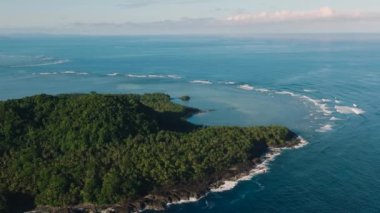 Tropikal adanın insansız hava aracı görüntüsü. Güneş ışığı ve dalgalar. Surigao del Sur. Filipinler.