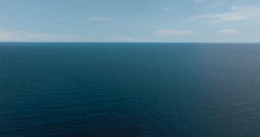 Mavi okyanus, sakin su yüzeyinin sakin deniz uyumu. Mavi su ve gökyüzü manzarası, üst manzara. Camiguin, Filipinler.