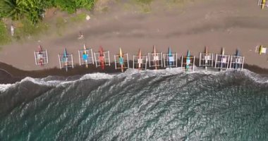 Kumlu sahil şeridi ve geleneksel balıkçı tekneleri. Turkuaz su ve dalgalar Camiguin Adası 'nda. Filipinler.