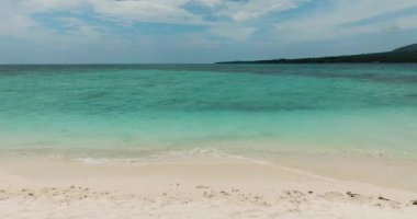 Beyaz kumlu sahil şeridi ve yeşil okyanus dalgaları. Beyaz Ada. Camiguin, Filipinler.