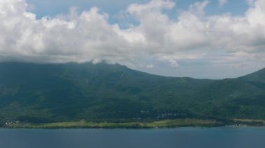 Derin mavi denizi olan tropik bir ada. Mavi gökyüzü ve bulutlar. Camiguin, Filipinler.