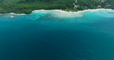 Samal Adası 'ndaki kumsalın havadan görünüşü ve beyaz kum. Mavi deniz ve dalgalar. Davao, Filipinler.