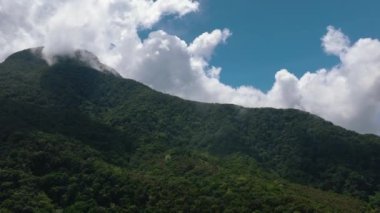 Ormanı ve ormanı olan tropik bir dağ. Mavi gökyüzü ve bulutlar. Camiguin Adası. Filipinler.
