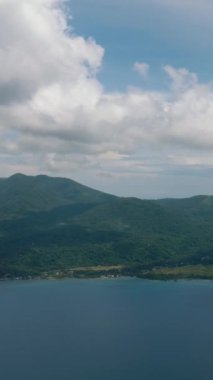 Camiguin Adası 'nda derin mavi deniz. Mavi gökyüzü ve bulutlar. Filipinler. Dikey video.