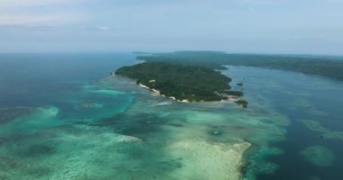 Tropikal adada kumlu sahil şeridi ve gök mavisi okyanus suyu ve balık çiftlikleri. Barobo, Surigao del Sur. Filipinler.