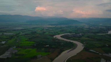 Nehir kenarındaki tarlalar, çeltik tarlaları. Çiftçilerin tarım arazisi. Mavi gökyüzü ve bulutlar. Bukidnon, Filipinler. Mindanao..