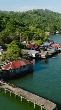 Kıyıya yakın Lanao del Norte 'nin yeşil sularıyla balıkçı köyü. Mindanao. Filipinler. Deniz Burnu. Dikey video.