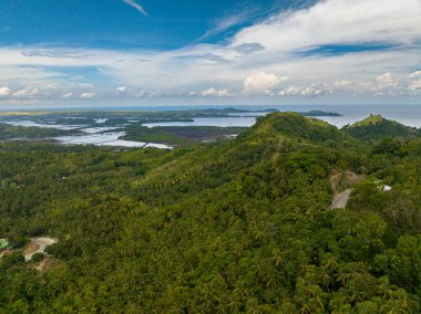 Filipinler 'in kıyı şeridinde bir dağ kayalığı. Mavi gökyüzü ve bulutlar. Mindanao..