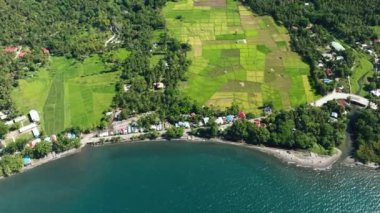 Filipinler 'deki Camiguin Adası kıyılarındaki deniz suyu ve tarım arazisine güneş yansıması.