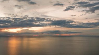 Gün batımının deniz üzerinde yansıdığı bulutlu bir manzara ve Camiguin Adası 'nda dalgalar. Filipinler.