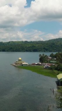 Lanao del Sur 'daki Lanao Gölü ve Linuk Camii' nin havadan görünüşü. Mavi gökyüzü ve bulutlar. Mindanao, Filipinler. Dikey görünüm.