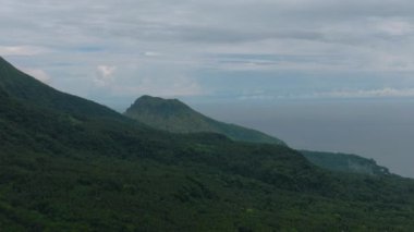 Camiguin Adası 'ndaki dağlar ve yeşil tepeler. Dağların yamaçlarında hep yeşil bitkiler olur. Filipinler.