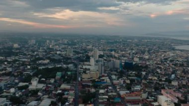 Modern binaları ve köyü olan Davao City. Bulutlu gün batımı manzarası. Mindanao, Filipinler.